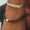 Perlenarmband aus Lava mit handgraviertem Sonnen Symbol
